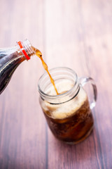 pouring coca cola sparkling water into a glass