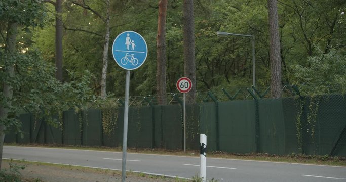 German street signs and a car passing by.