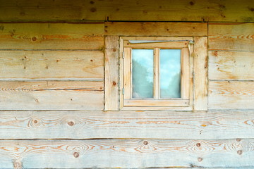 Obraz na płótnie Canvas window in the wall of a wooden log house.