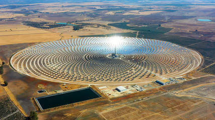 Aerial view of a large circular power plant of solar panels in Spain. There is the reflection of the sun in the the panels which produce renewable energy - environment concept - 290877525