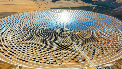 Beautiful large circular power plant of solar panels in Spain. There is the reflection of the sun in the the panels which produce renewable energy, solar energy - close-up view with a drone - environm - 290877540