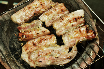 Streaky pork on a charcoal grill