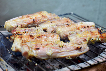 Streaky pork on a charcoal grill