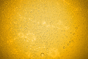 Water drops on yellow glass, Rain droplets on glass background.