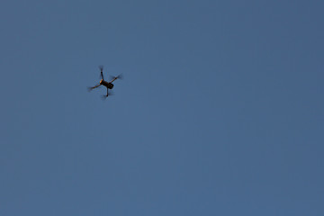 Copy space. Flying a quadcopter in the blue sky. Car on blue background