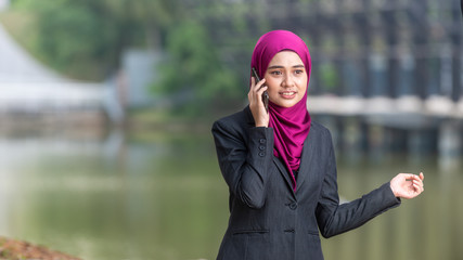 Muslim Corporate Lady talking on her smartphone. Outdoor Setting. Negative Space for text