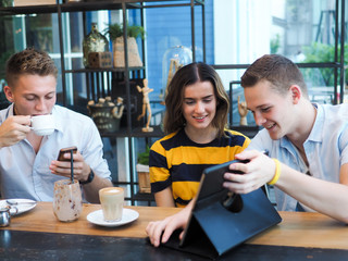 Smart man and woman using tablet and drinking coffee in cafe, lifestyle concept.