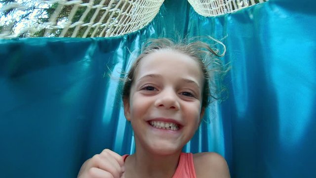 young girl sliding down a soft enclosed slide. Close up