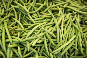 A close up of a pile of green beans at the farmer's market