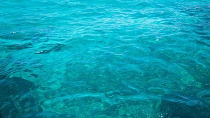 Fototapeta na wymiar Blue clear water. Beautiful blue sea wave photograph close up. Beach vacation at sea or ocean.