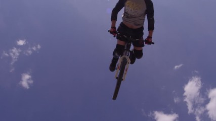 Extreme sports BMX flip over the camera and blue sky