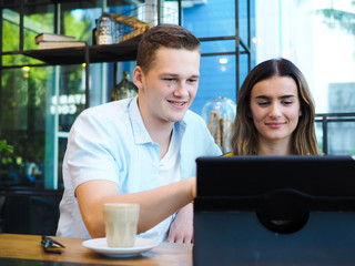 Smart man and woman using tablet and drinking coffee in cafe, lifestyle concept.