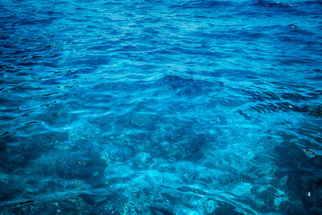 Fototapeta na wymiar Blue clear water. Beautiful blue sea wave photograph close up. Beach vacation at sea or ocean.