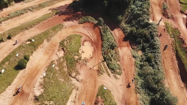 Bird's eye view of the motocross track. Training session with a motorbike in enduro park on a sunny day.