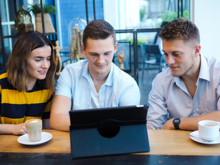 Smart man and woman using tablet and drinking coffee in cafe, lifestyle concept.