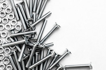 Top view of stainless steel bolts or iron nails on brigth white background with silver color. Metal screws for use in sheet metal.