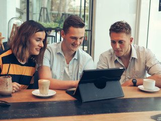 Smart man and woman using tablet and drinking coffee in cafe, lifestyle concept.