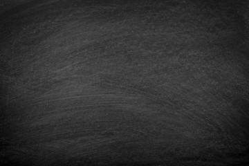 Fototapeta premium Working place on empty rubbed out on blackboard chalkboard texture background with colorful crayons chalk for classroom or wallpaper, add text message.