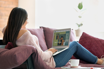 Young fashion blogger with laptop at home