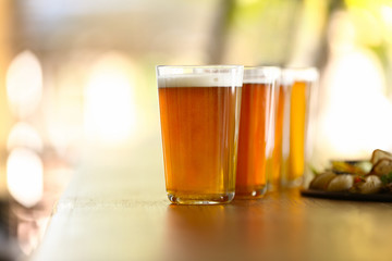 Glasses of fresh beer and snacks on table in pub