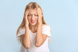 Stressed young woman on color background