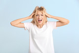 Stressed young woman on color background