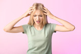 Stressed young woman on color background
