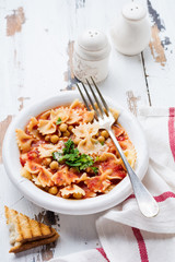 Traditional Italian dish, chowder, pottage, pasta e ceci served in old plate on old wooden background. Rustik style. Top view.