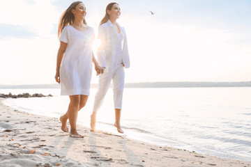 Beautiful lesbian couple walking along a river bank