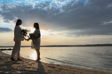 Beautiful lesbian couple on their wedding day near river