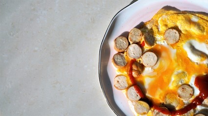 fried eggs and sausages with tomato sauce