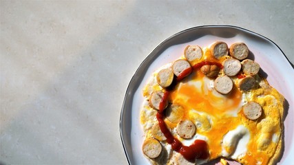 fried eggs with tomato catchup and slicedc sausages