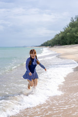 Happy woman is Enjoying and running  Summer Vacation on the beach