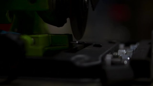 Angle grinder machine removes screwdriver tip sparks fly in super slow motion dark shadows