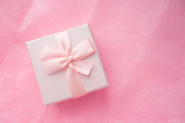 Top view of pink gift box with ribbon bow on pink craft background. Craft pink paper gift box with as a present for Christmas, new year, valentine day or anniversary on pink background, copy space