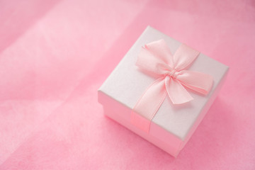 Pink gift box with ribbon bow on pink craft background. Craft pink paper gift box with as a present for Christmas, new year, valentine day or anniversary on pink background, copy space