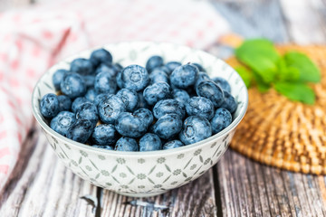 Myrtilles fraichement cueillies dans un bol et menthe fraîche