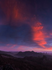 Fototapeta premium Mountain view morning of red clouds moving above top hills with blue sky background, twilight at Ban Ja Bo Hill Tribes Village, Pang Mapla, Mae Hong Son, northern of Thailand.