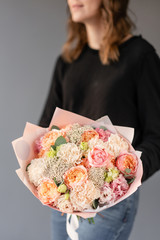 Beautiful bouquet of mixed flowers in womans hands. the work of the florist at a flower shop. Fresh cut flower.