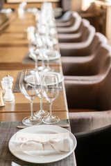 Wine glasses in the foreground. Wedding Banquet or gala dinner. The chairs and table for guests, served with cutlery and crockery.