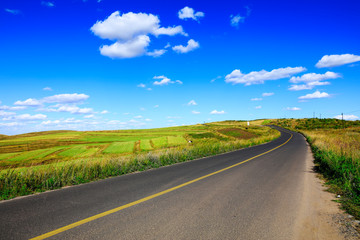 The asphalt road is on the prairie