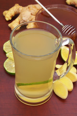 Glass cup of fresh ginger tea with lime and honey