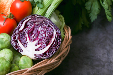 Obraz premium Fresh vegetable preparation for making food. There are lettuce, green parsley, sweet conn, tamoto, cabbage, bell chili on rattan basket with rustic cloth as background
