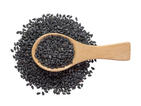 Black sesame seeds in wooden spoon and spread isolated on white background.Scientific name is Sesamum orientale L.Herb.cereal. top view.