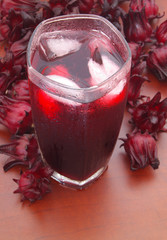 Hibiscus sabdariffa or roselle flowers cold tea on wooden table