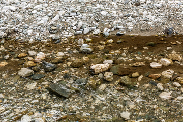 Detail of surface texture with small pebble rock on dirty ground