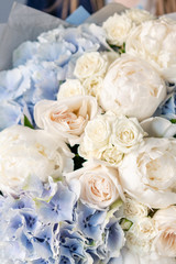 White peonies and blue hydrangea. Beautiful bouquet of mixed flowers in woman hand. Floral shop concept . Handsome fresh bouquet. Flowers delivery