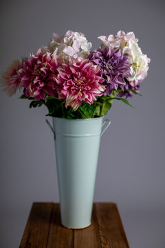Silk flowers in a tall metal vase