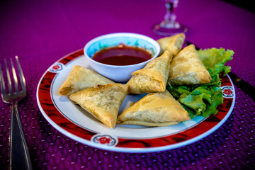Assiette de samoussas avec sa sauce vue de trois quart