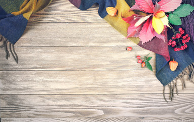Autumn leaves and scarf top view empty space wooden background.